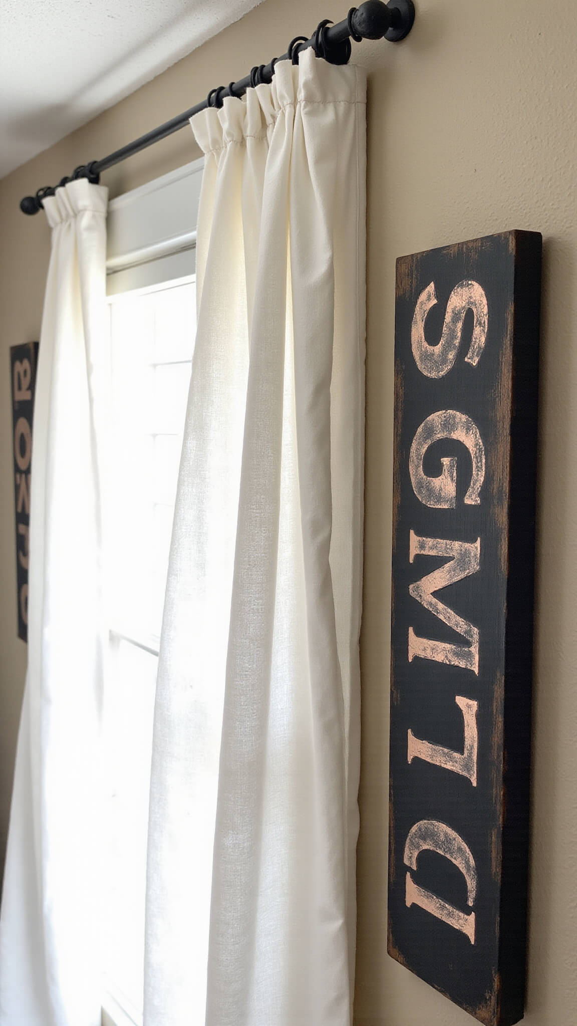 Closeup of DIY ghost drapes from aged cotton sheets blowing in breeze, handpainted wooden signs with matte black and copper lettering, framed by natural corn stalks.