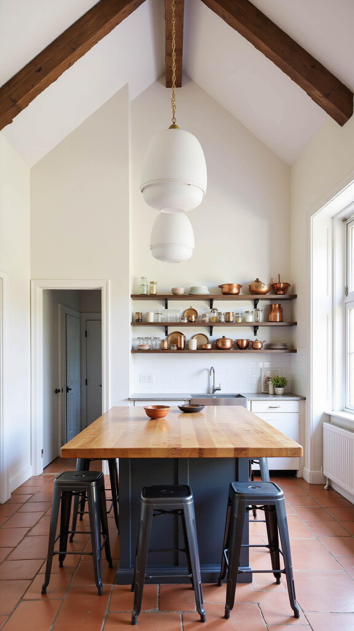 Late afternoon kitchen with 12ft cathedral ceiling, distressed wood beams, large butcher block island, industrial stools, open shelves displaying copper cookware and mason jars, and warm terracotta tile floor.