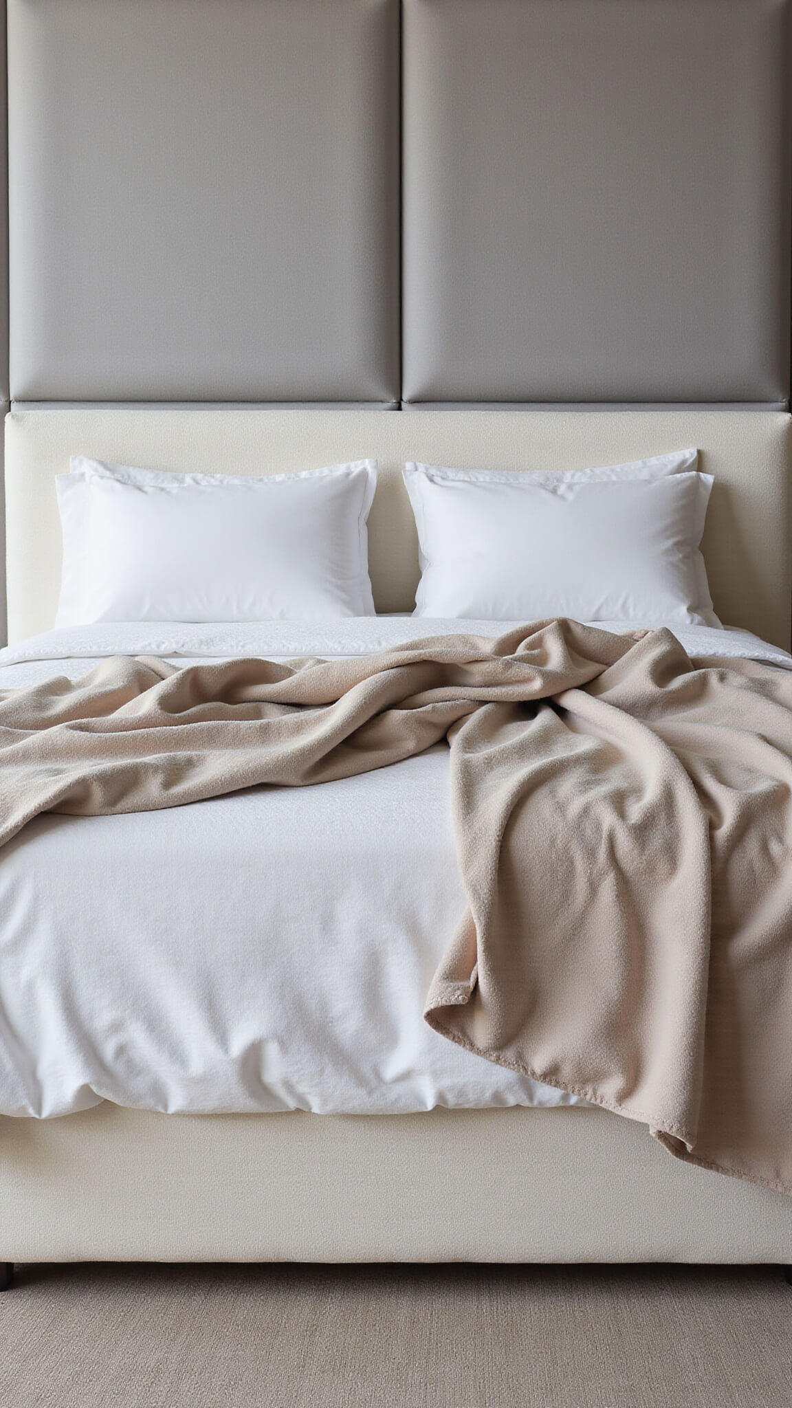 Luxurious cream bouclé upholstered bed with layered silk blanket, memory foam pillows, and organic cotton duvet; soft grey wool acoustic panels and diffused lighting enhance cozy, textured ambiance.