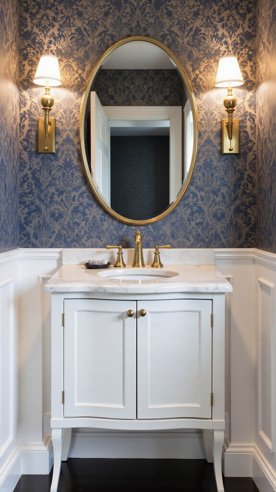 Luxurious 6x8ft powder room with classic damask wallpaper, marble vanity, unlacquered brass fixtures, oval champagne mirror, navy walls, white wainscoting, and soft sconce lighting.